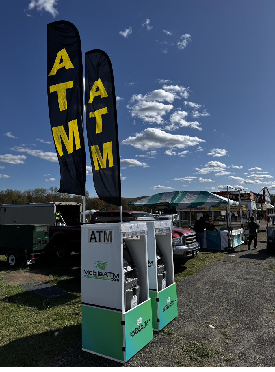 MobileATM machines deployed at outdoor event with ATM flags